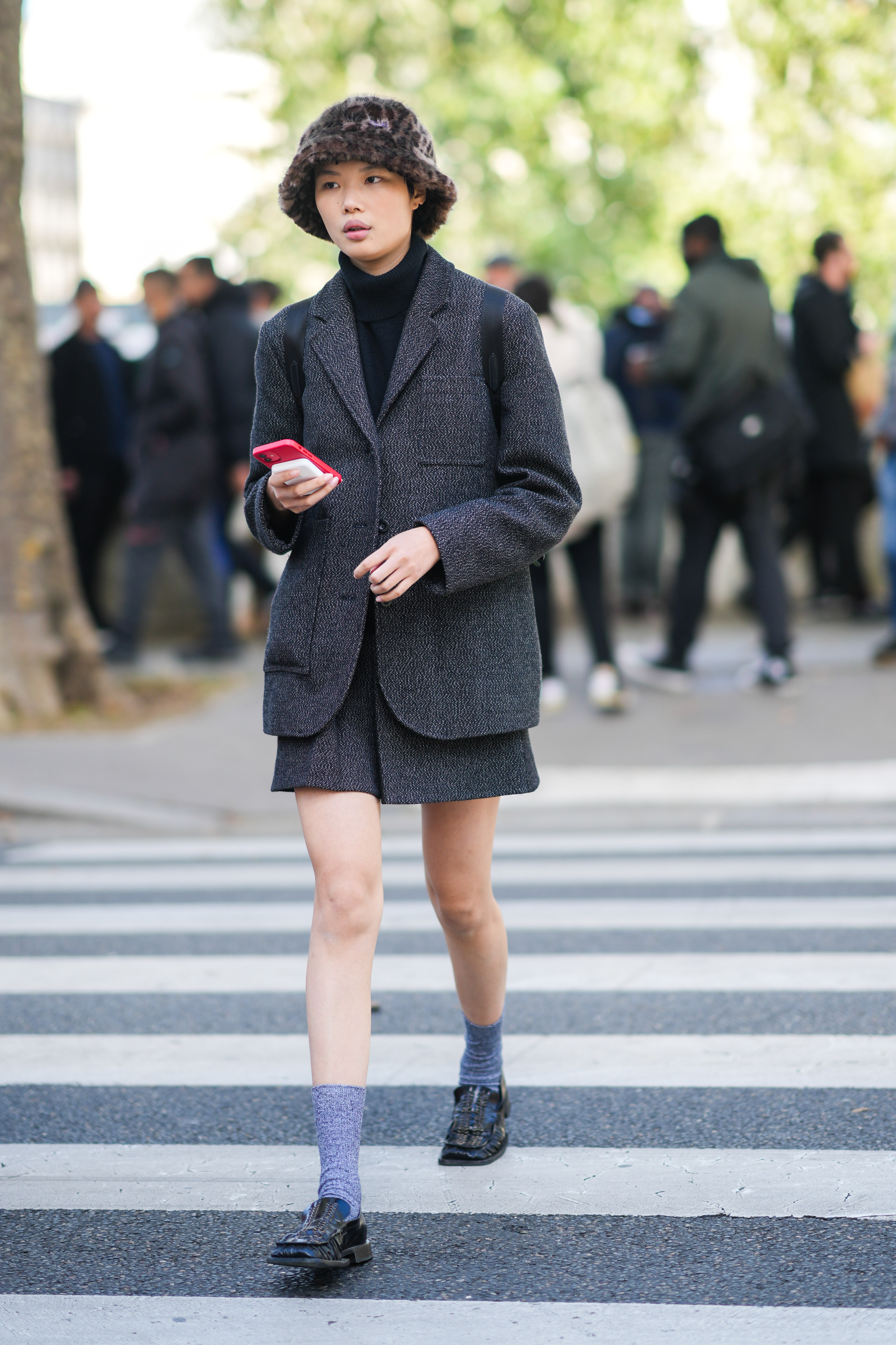 a model wears a miniskirt and loafers