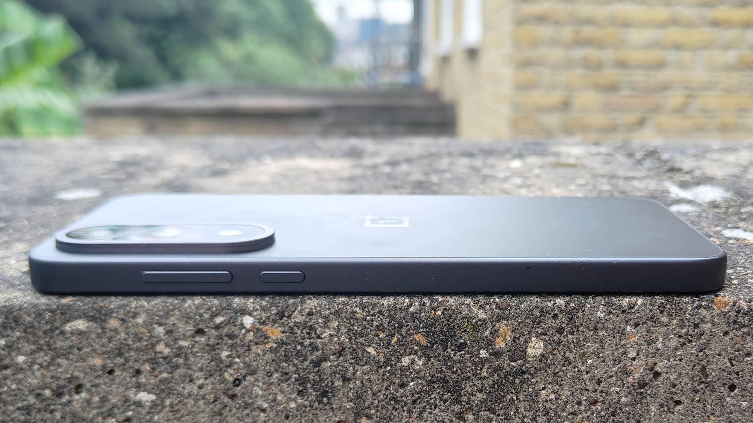 The OnePlus Nord 5 on a brick wall.