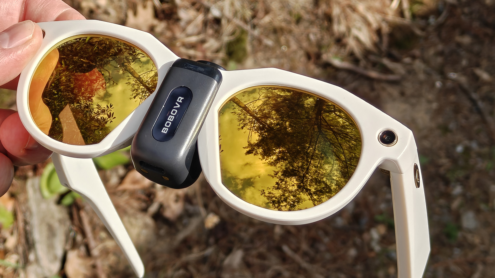 A BoboVR CG2 battery attached to a pair of white Oakley Meta HSTN smart glasses