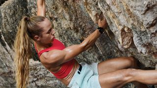 Woman climbing outdoors while wearing Garmin Fenix 7 smartwatch