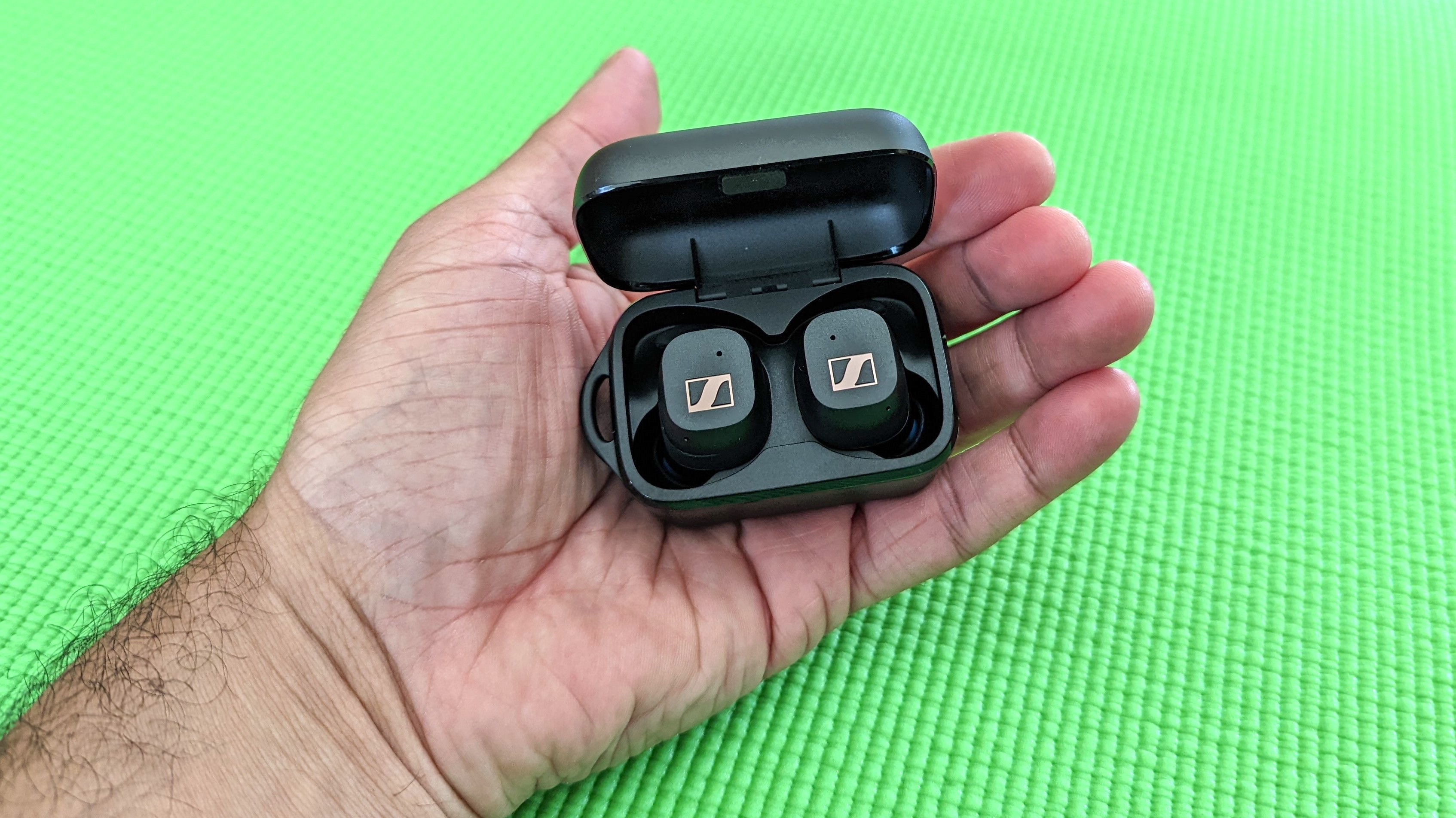 The Sennheiser Sport True Wireless charging case being held in hand