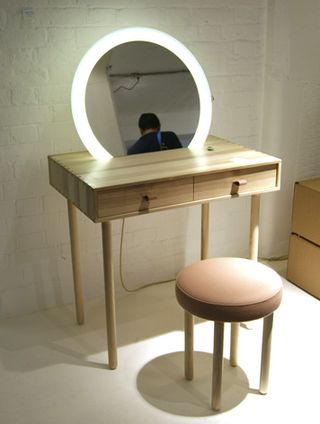 Finely crafted from solid ash, the 'Avignon' dressing table by Hungarian design studio Codolagni features a circular mirror lined with LEDs, wool draw pulls and a wool upholstered stool