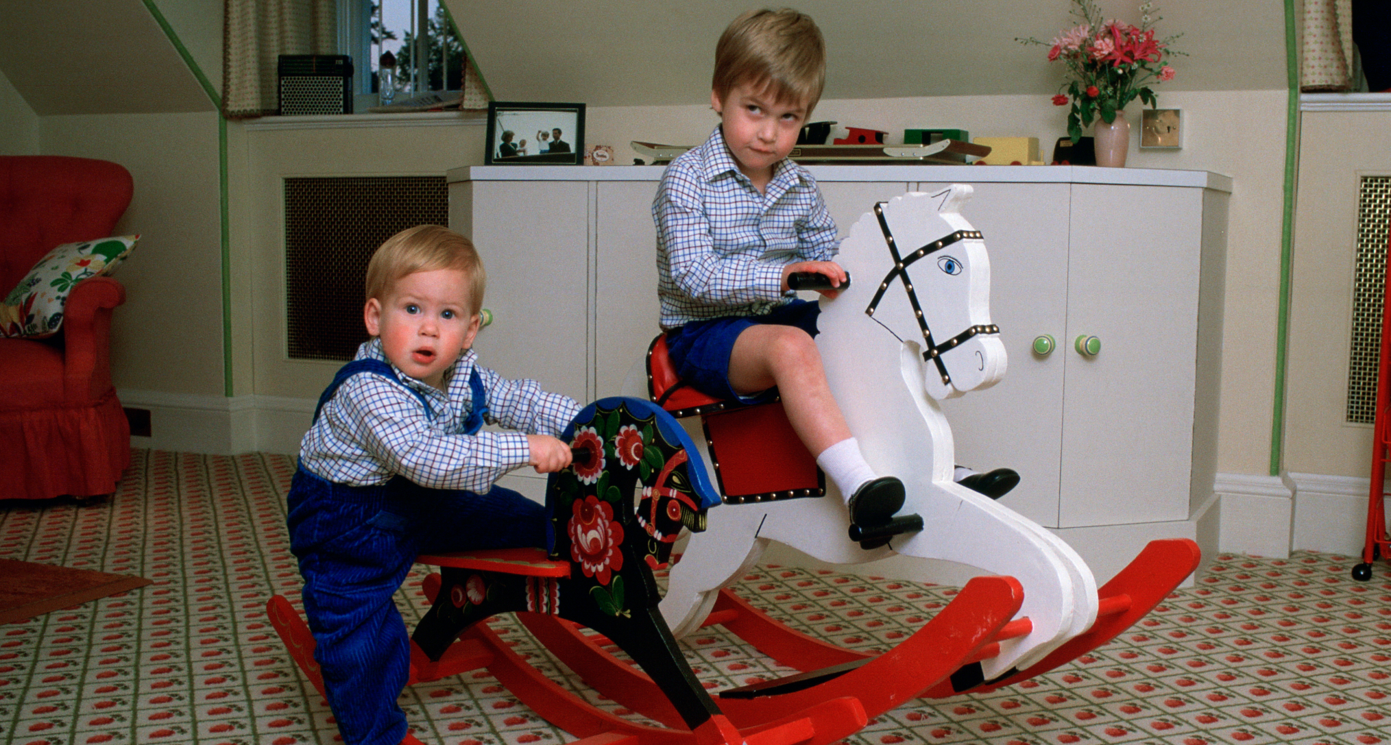 Prince William and Prince Harry on rocking horses in their play room