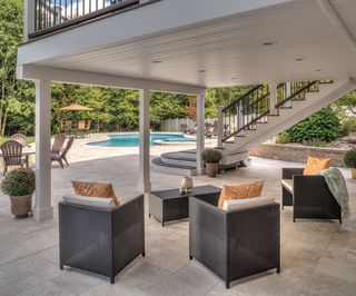 covered patio area with garden furniture and pool