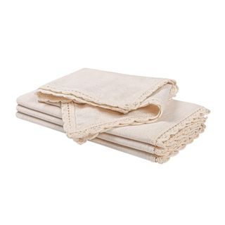 A set of four cream linen napkins with lace trims