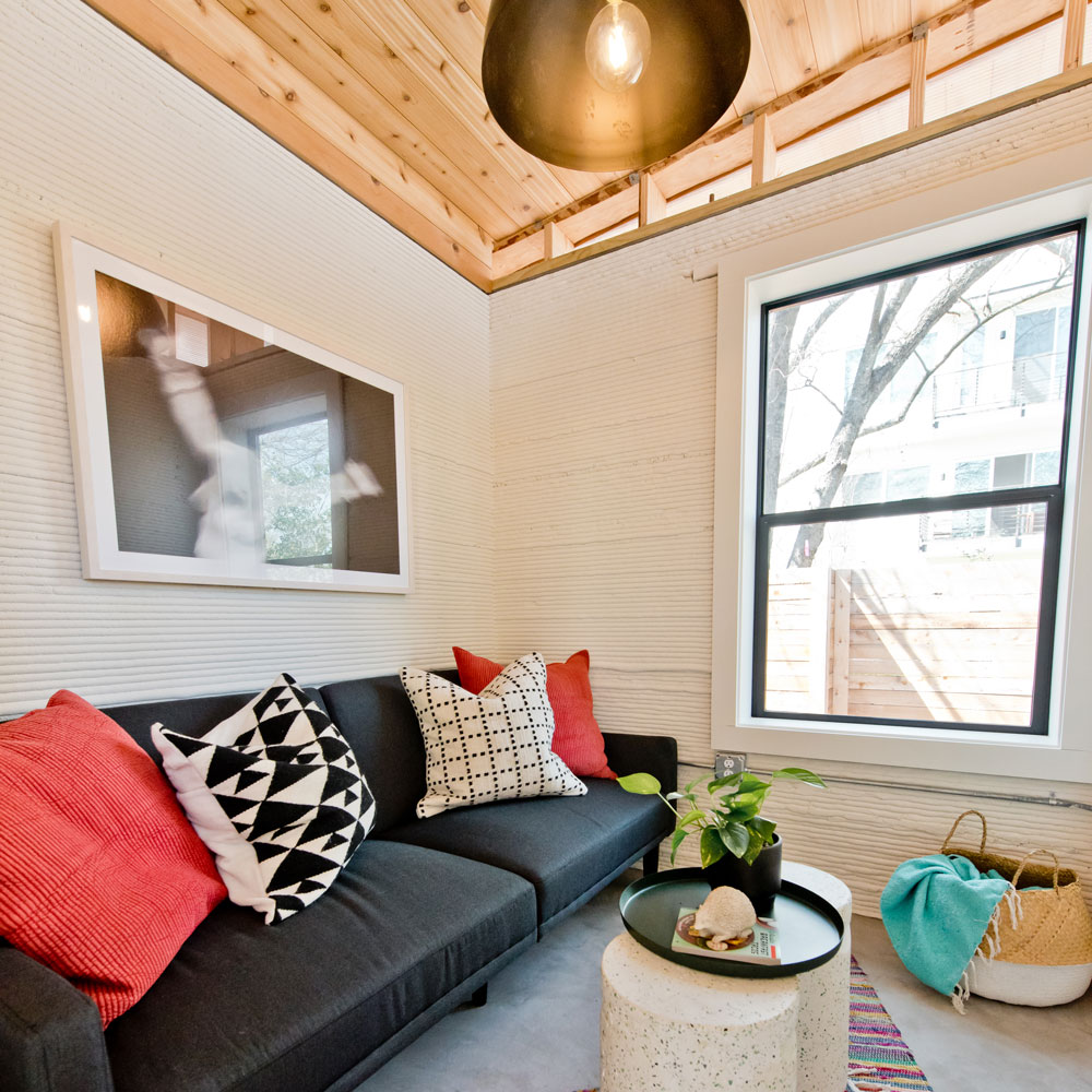 wooden flooring white walls and sofa set with cushons