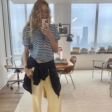 @olympiamarie taking mirror selfie wearing striped shirt and yellow pants