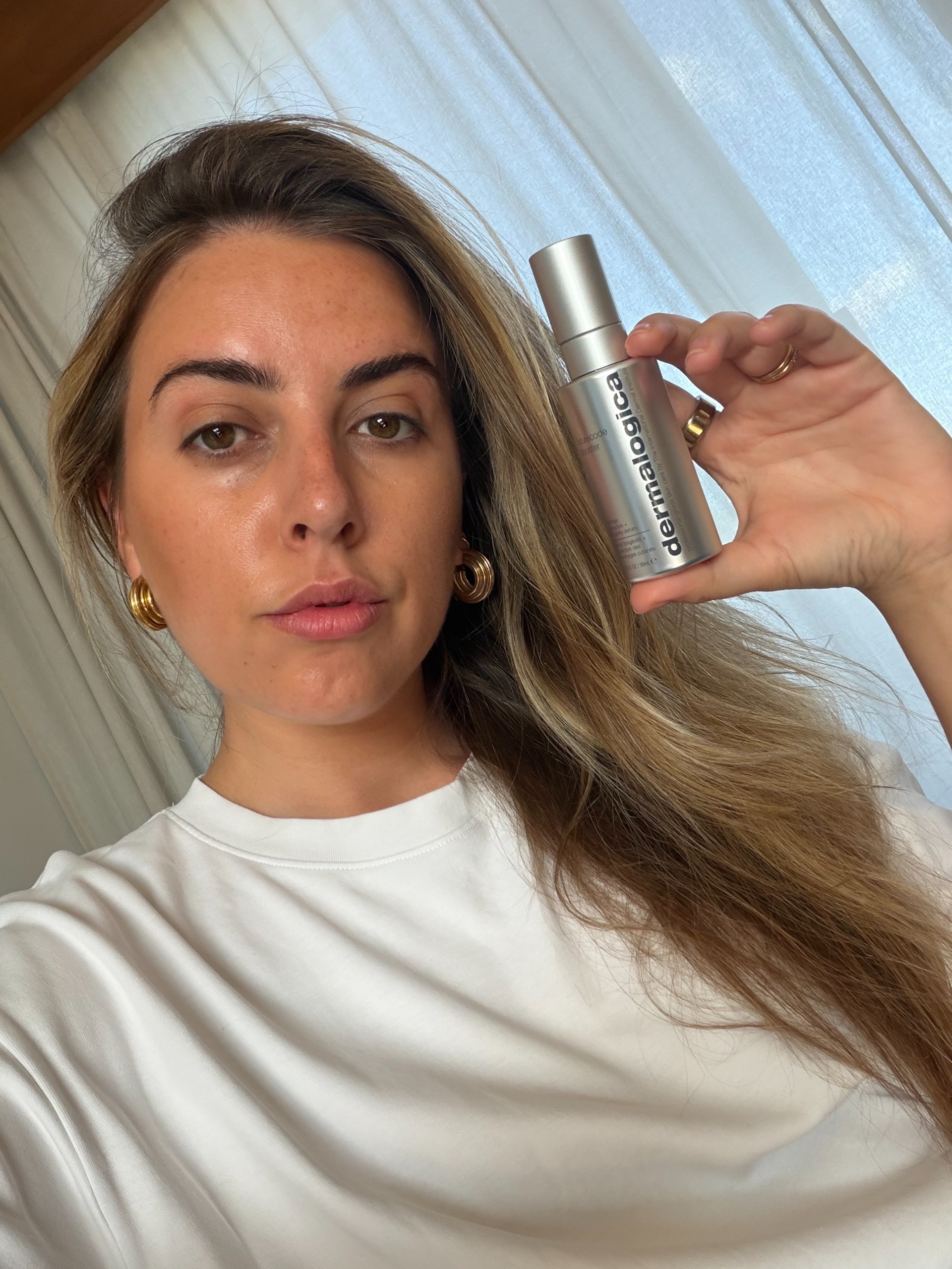 Shannon Lawlor holding up a bottle of Dermalogica Futurecode Booster next to her face
