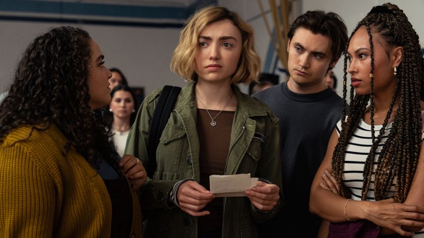 Maddie (Peyton List) holding a piece of paper, while her classmates next to her look at her in doubt.