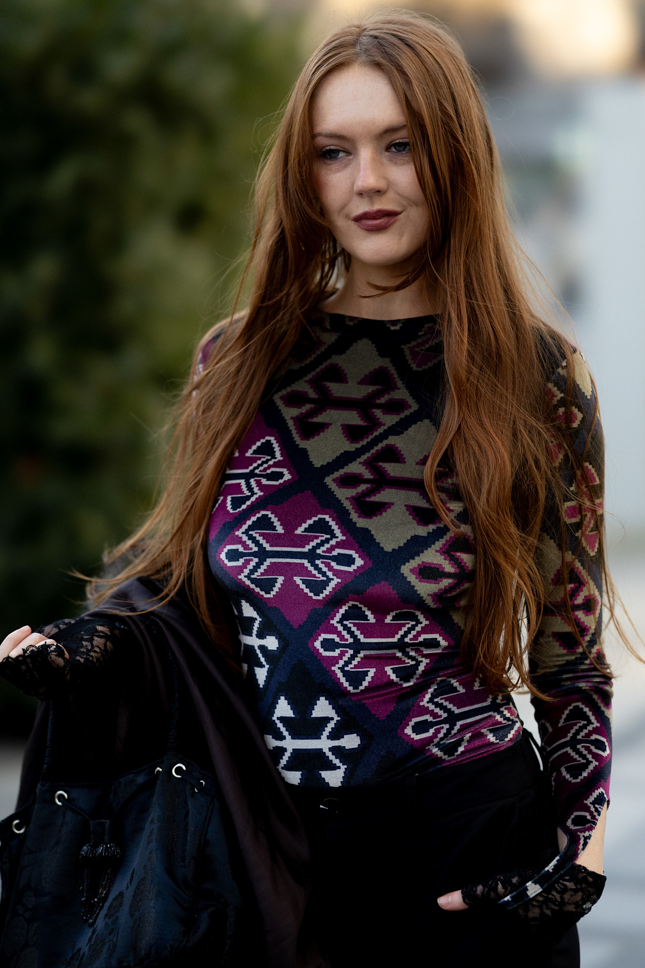 a woman in a purple and black sweater with long brown hair
