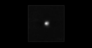 A white dot sits on a dark background