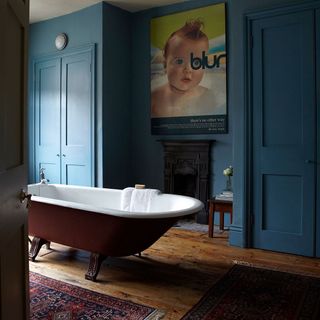 Blue indigo wall with wooden flooring and bathtub