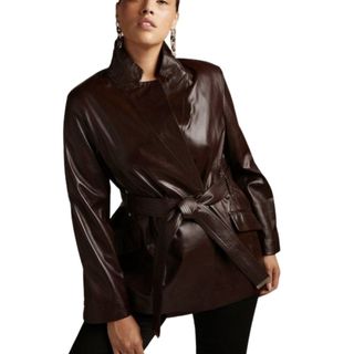 model wearing burgundy wrap front short leather jacket with belt