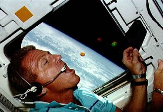 NASA astronaut Loren Shriver eats M&M's candy in weightlessness aboard the space shuttle Atlantis during the STS-42 mission in 1992.