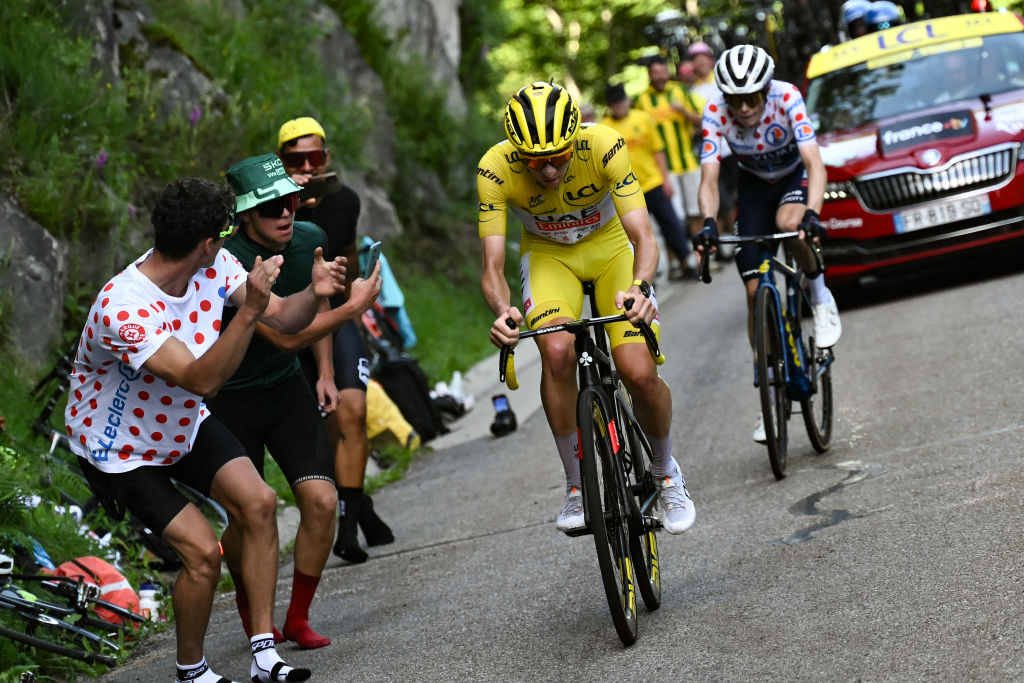 UAE Team Emirates team's Slovenian rider Tadej Pogacar wearing the overall leader's yellow jersey (L) takes the lead ahead of Team Visma - Lease a Bike team's Danish rider Jonas Vingegaard (R) in the final ascent of the Plateau de Beille during the 15th stage of the 111th edition of the Tour de France cycling race, 197,7 km between Loudenvielle and Plateau de Beille, in the Pyrenees mountains, southwestern France, on July 14, 2024. (Photo by Marco BERTORELLO / AFP)