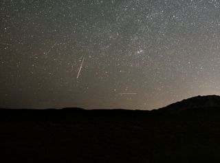 A Lyrid meteor streaks across the star-speckled sky near Prescott, Arizona, in this photo taken by Jason Robbins on April 22, 2020. A few faint airplanes streak through the background in the distance.
