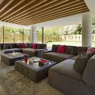 living room with wooden ceiling and sofa with cushions