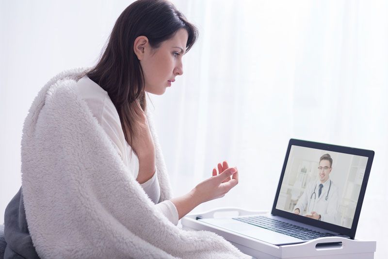 A woman consulting with a doctor via online video chat.