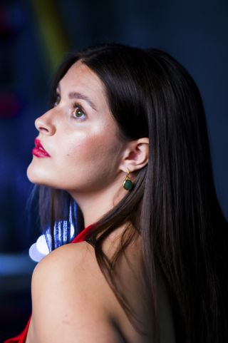 Female model with dark hair, red lipstick and in red dress, outdoors at night, taken with the Alice Camera