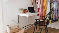 White desk in closet with colorful clothes