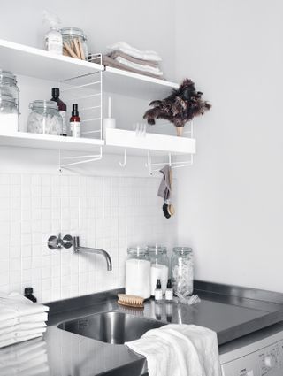 An example of utility room shelving ideas showing unfussy, white modular shelving