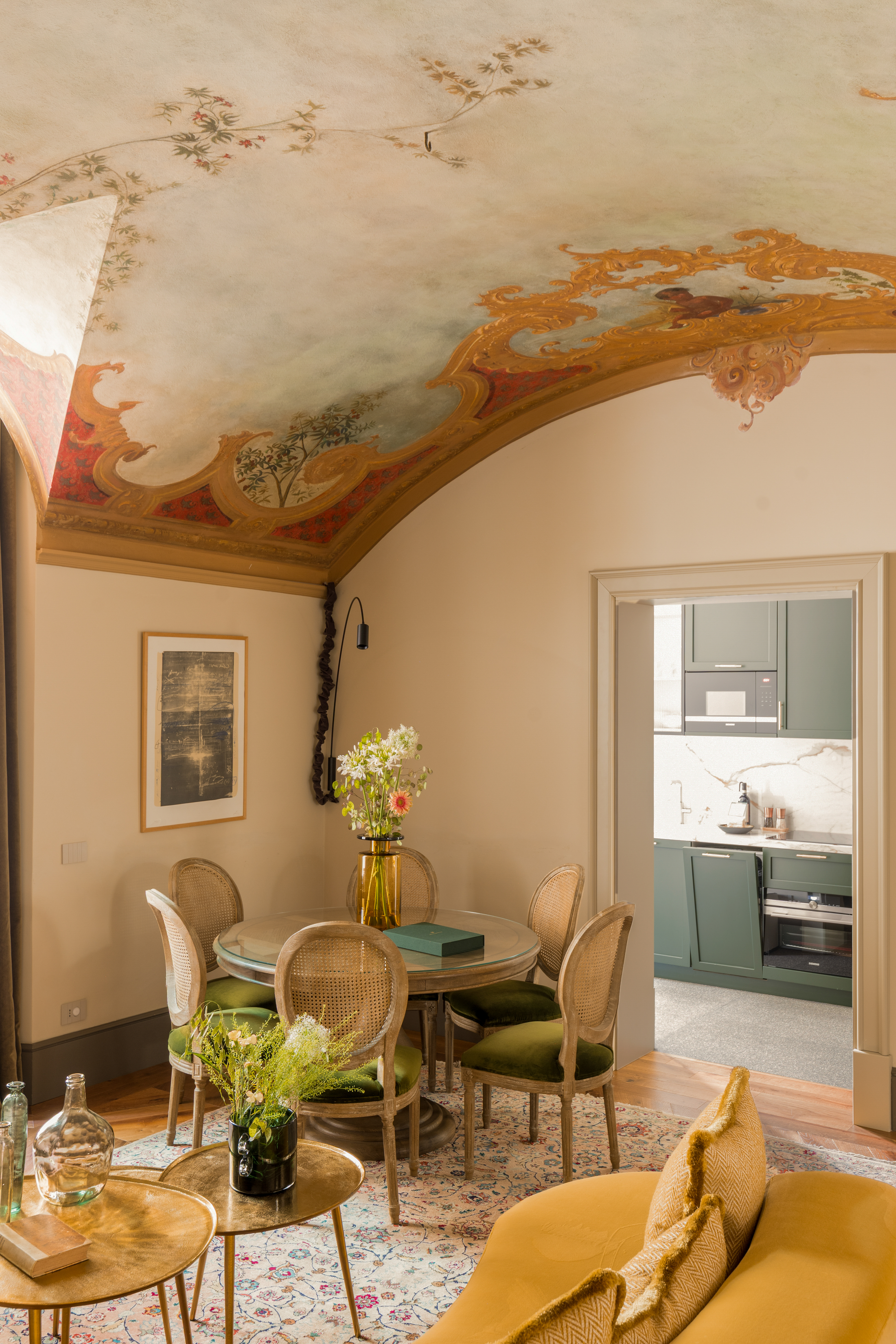 An ornate, palatial residence filled with sunshine, frescoed walls, terrazzo floors, vintage, modern, and plush contemporary furnishings, and thriving plants, whether indoors or on its terrace.