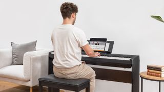 Man sits at a piano using the Flowkey app