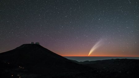 A comet shines after sunset over a European Southern observatory in Chile