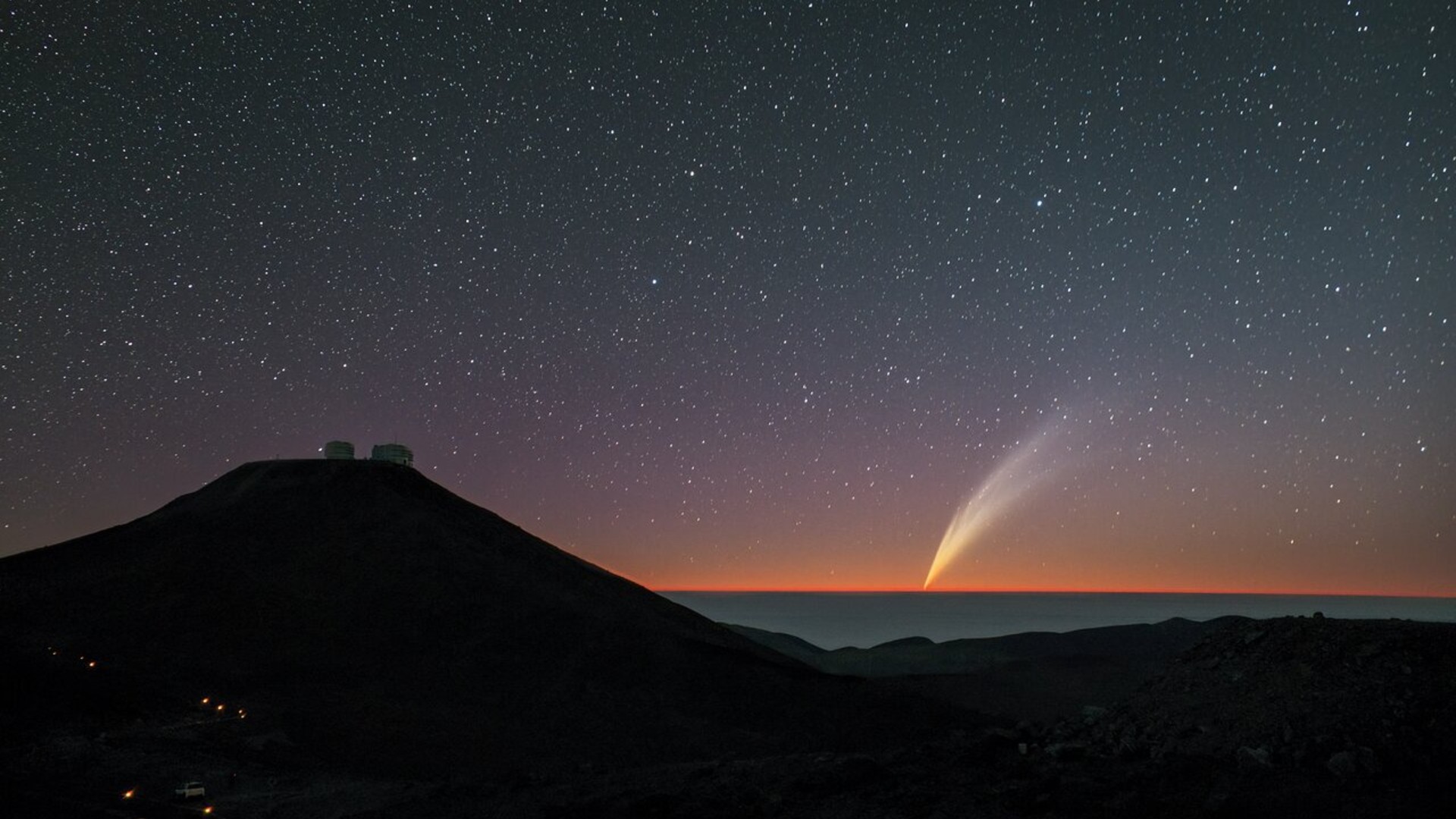 a bright wisp of light approaches the horizon beneath a star-filled sunset