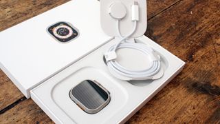 Apple Watch Ultra ja latauskaapeli vierekkäin myyntipaketissa