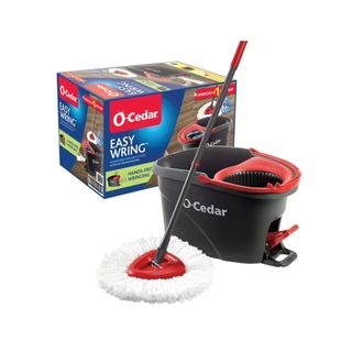 An O-Cedar mop with a white head and gray handle, next to a black and red mop bucket, with its packaging box behind it