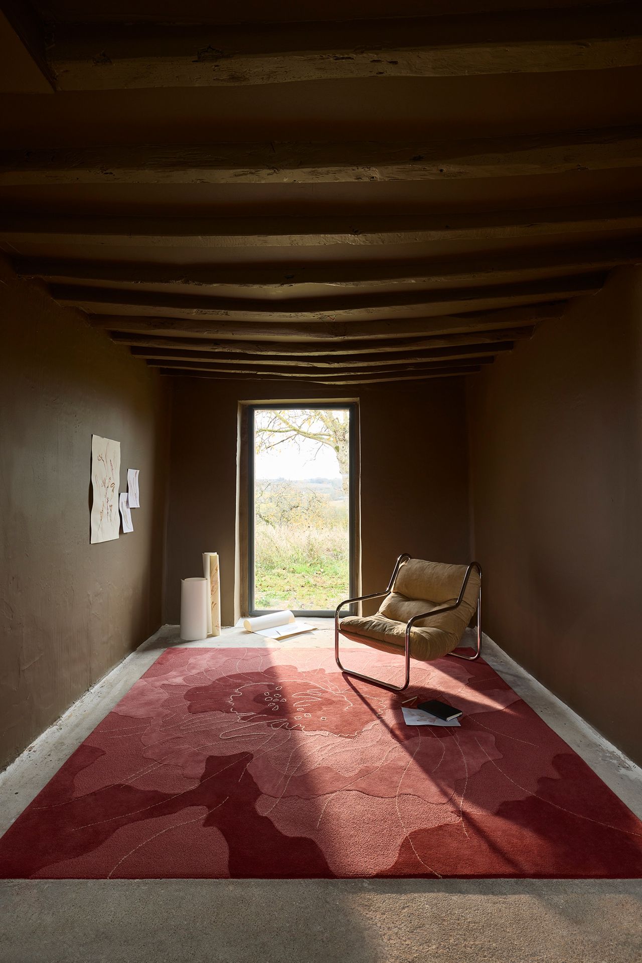 a brown living room space with a red floral rug
