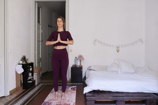 A woman doing yoga in her bedroom.