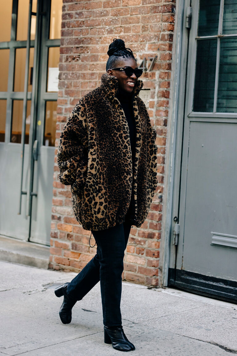 Nikki Ogunnaike wearing a leopard print coat, black jeans, black turtleneck sweater, black boots, and black sunglasses in new york city