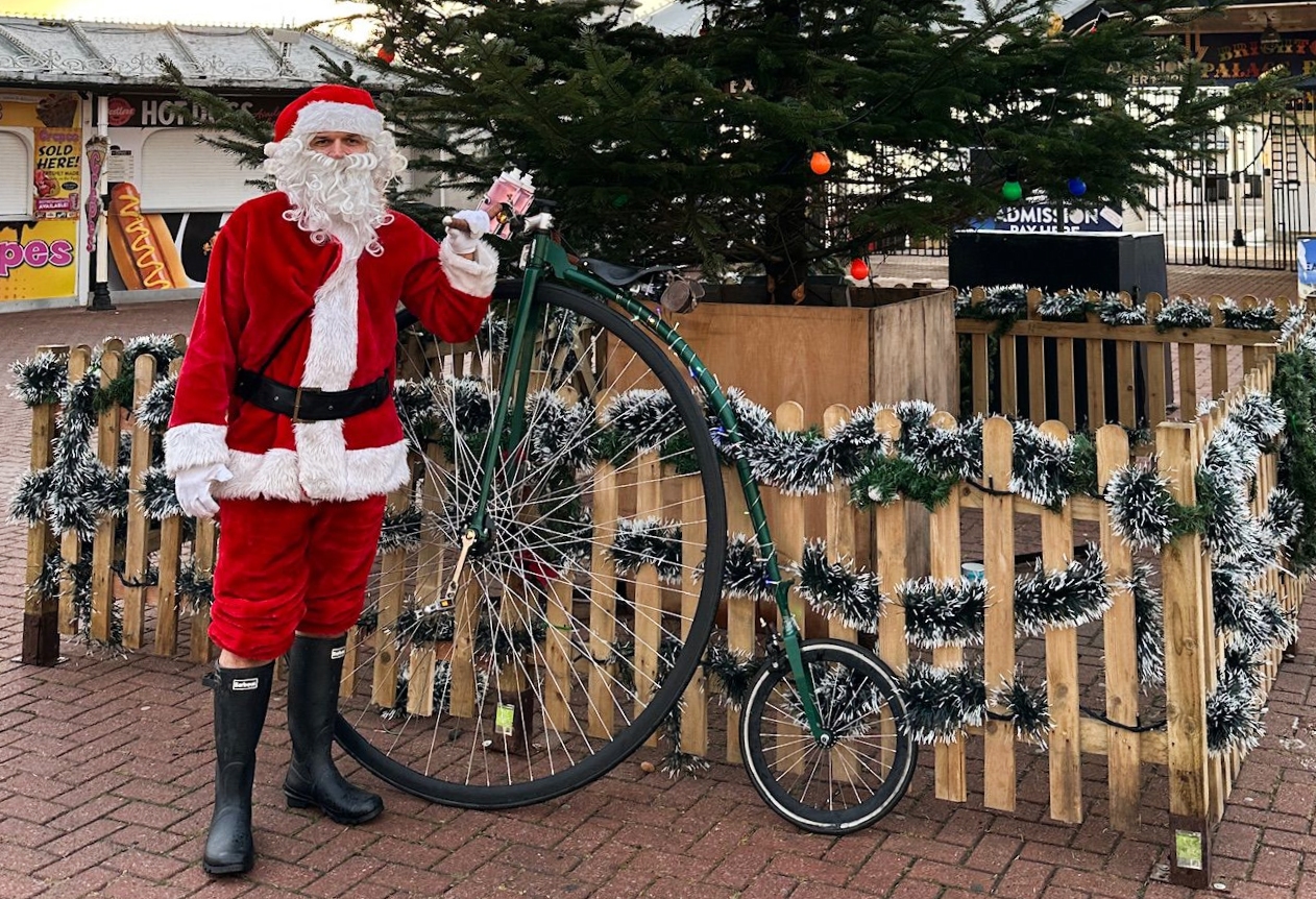 Charlie Burrell with a penny-farthing in a Santa costume
