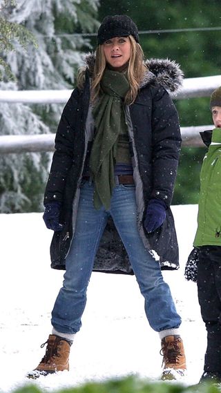 Jennifer Aniston wearing snow boots and oversized coat