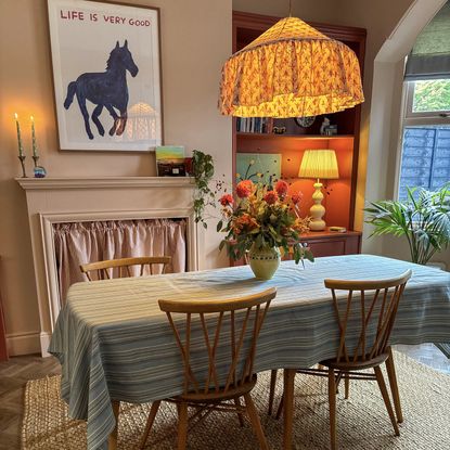 pink dining room with fabric light shades and wood chairs