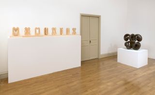 White room with wooden & black sculptures