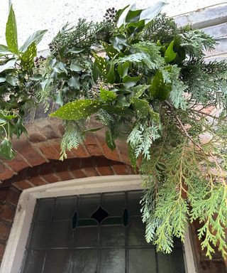 Mixed evergreen foliage in arch shape over a doorway