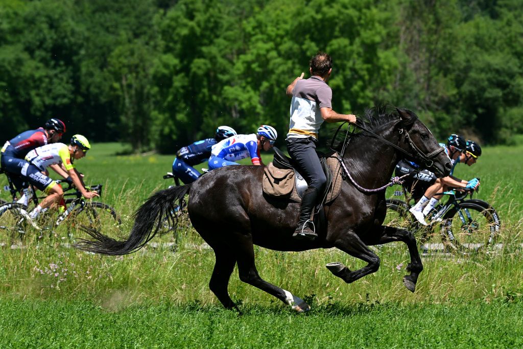 PLATEAU DE SALAISON FRANCE JUNE 12 The Peloton competes whilst a horse rider runs by side during the 74th Criterium du Dauphine 2022 Stage 8 a 1388km stage from SaintAlbanLeysse to Plateau de Salaison 1495m WorldTour Dauphin on June 12 2022 in Plateau de Salaison France Photo by Dario BelingheriGetty Images