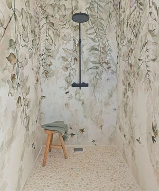 walk in shower with foliage wallpaper and stone floor