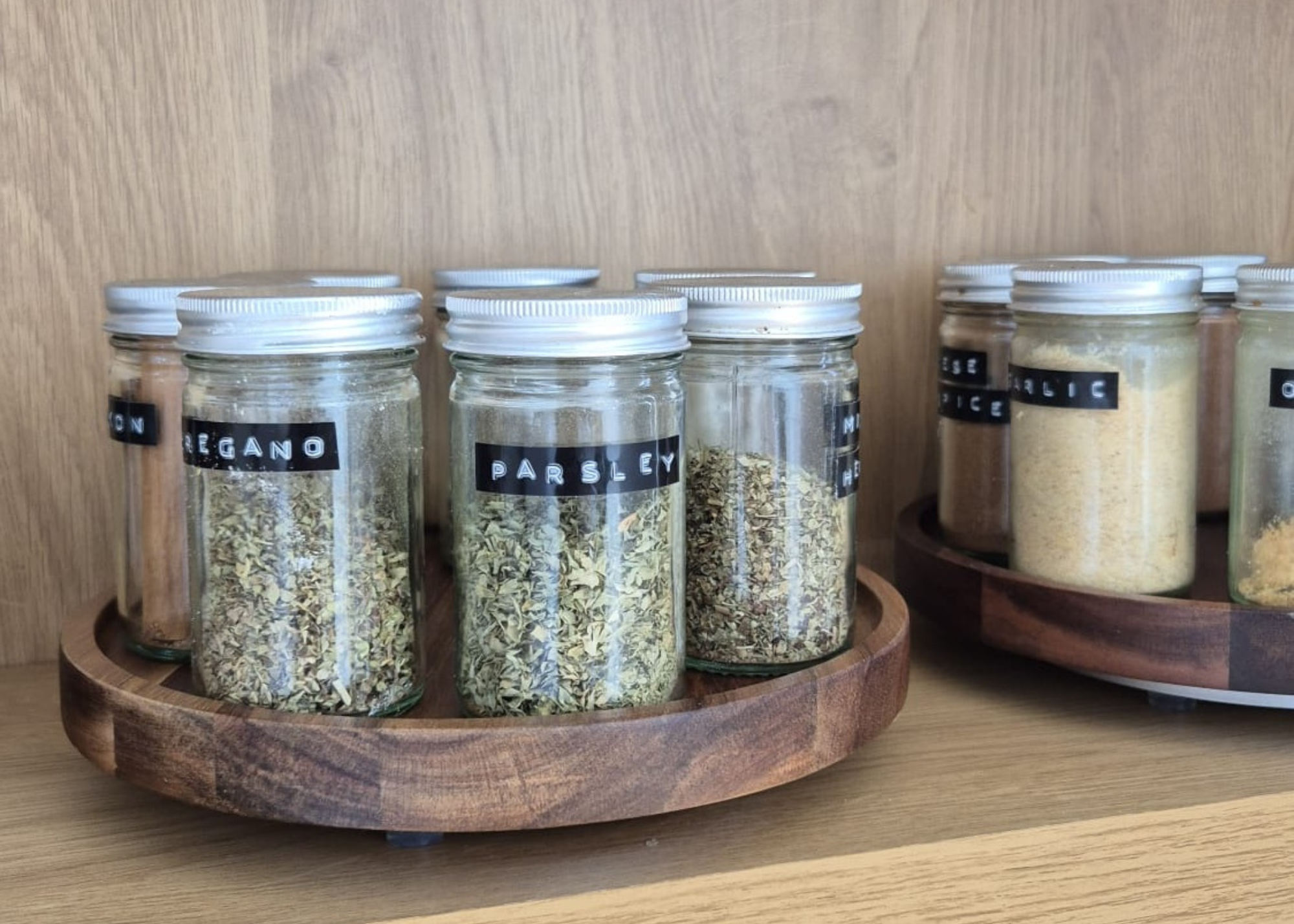 A set of glass spice jars on a wooden lazy susan