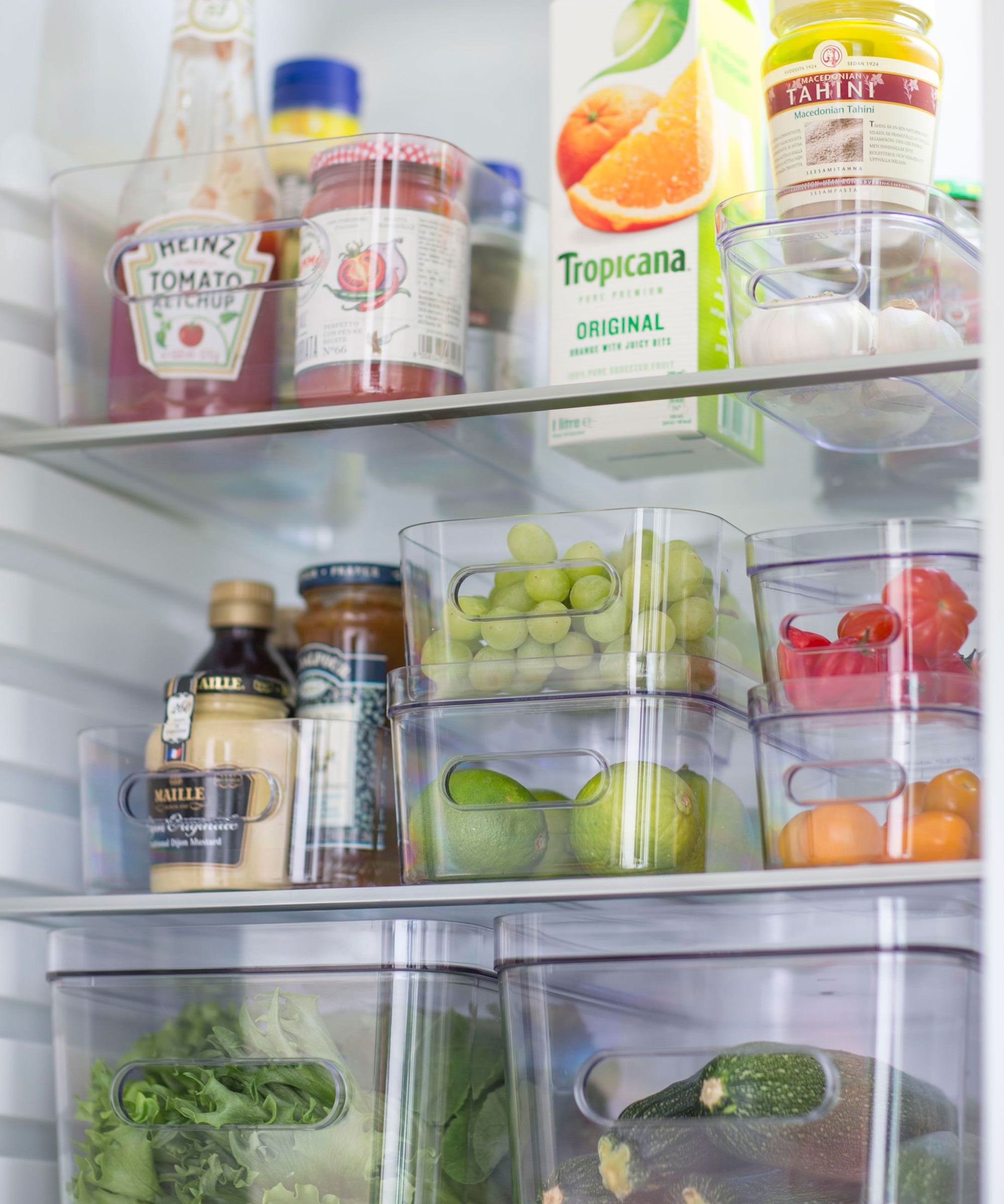 food arranged inside transparent plastic boxes in fridge