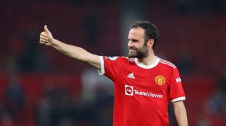 Juan Mata smiles and gives a thumbs up in a Manchester United home shirt at Old Trafford