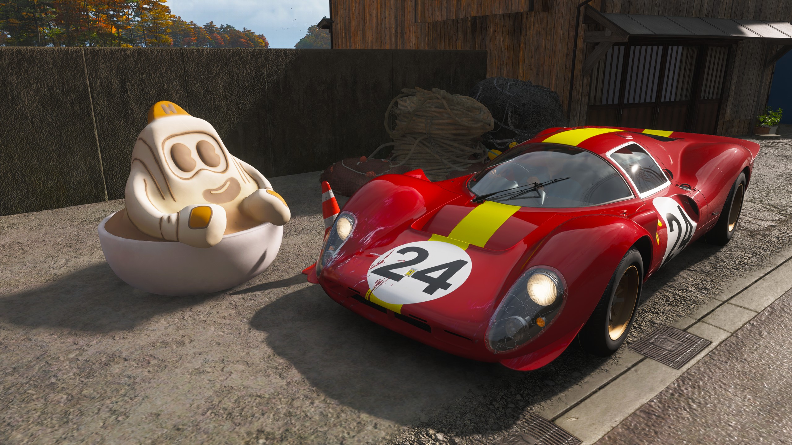 FH6 tank latte: A front-facing view of a classic red Ferrari parked on a driveway next to a large latte mascot.