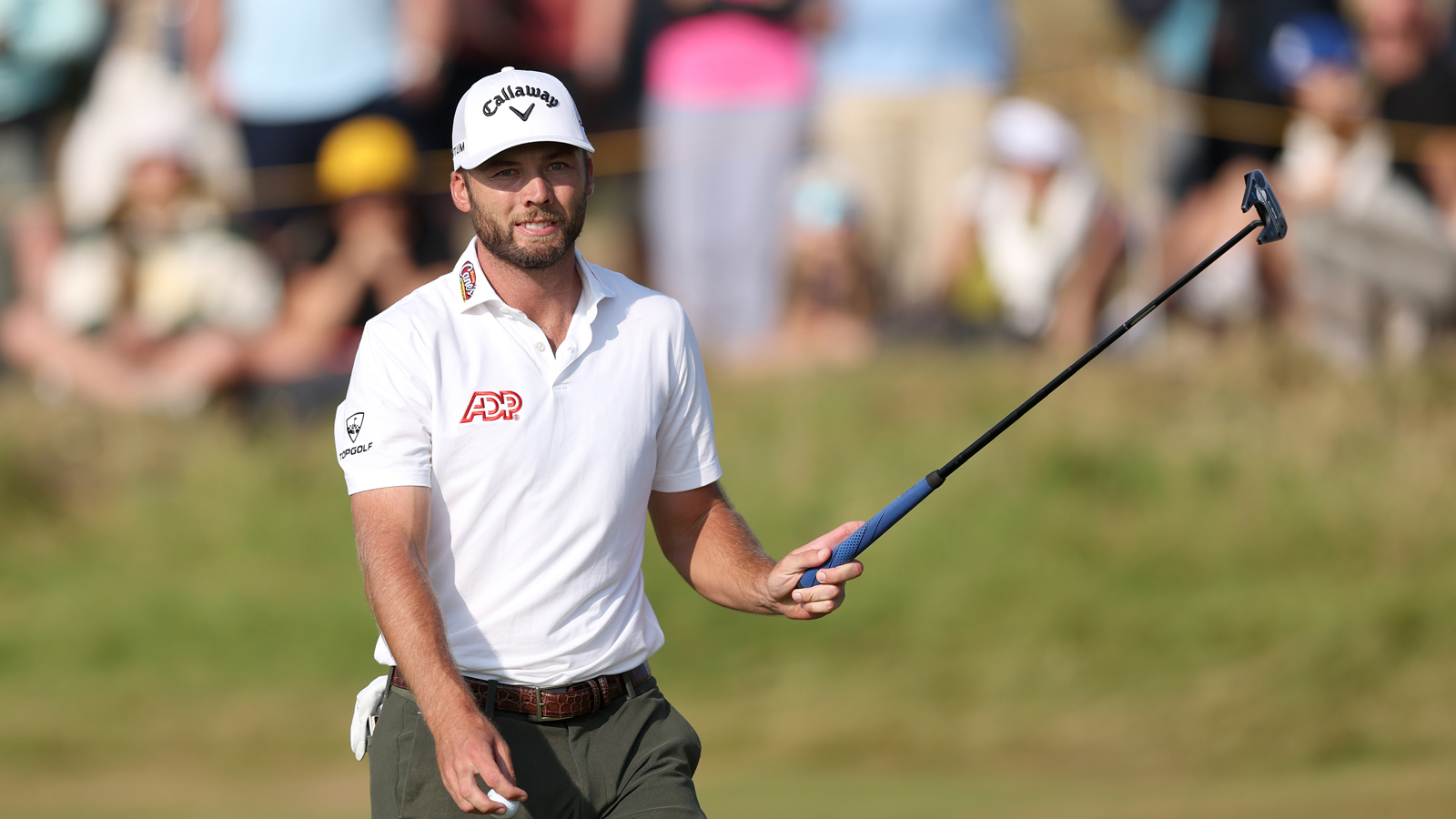 Sam Burns raises his putter in the air