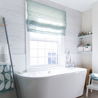 bathroom with grey designed wall bathtub and window