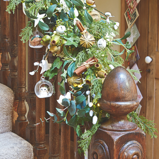 Close up of the stair bannister decorated with Christmas greenery, dried fruits and Christmas decorations. Karen and Chris Norton's Grade II listed Georgian semi detached four bedroom house in Market Lavington, Wiltshire.