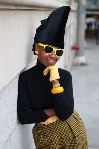 Lana Turner in an over 60 outfit featuring a black turtleneck, yellow plaid skirt, and yellow accessories