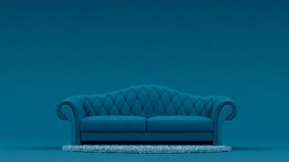 A blue sofa in front of a blue wall